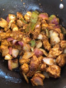 indian chicken in a pan cooked with peppers and onions