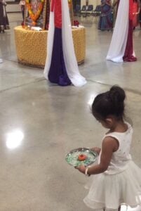 little girl holding an aarti dish