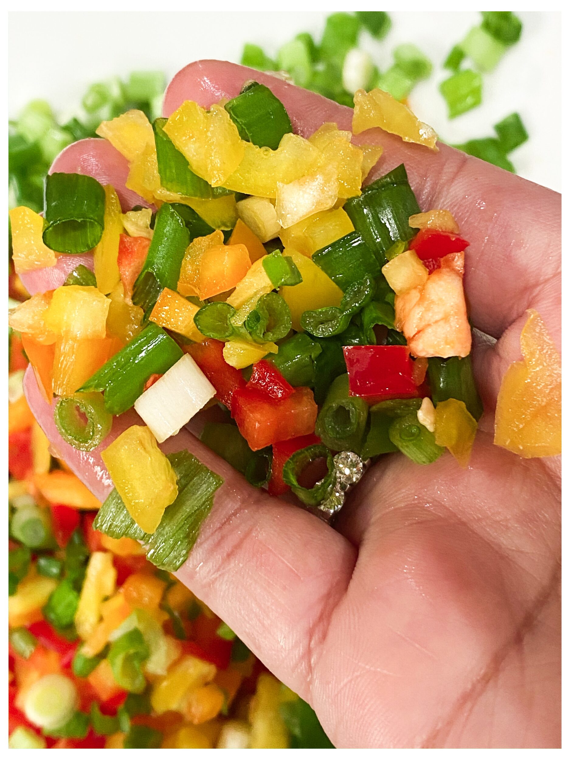 chopped bell peppers and onions in a hand