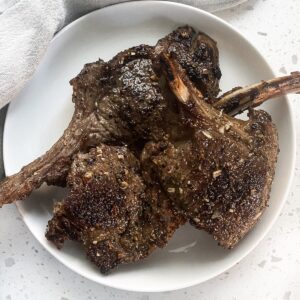 lamb chops in a round plate cooked with a crust