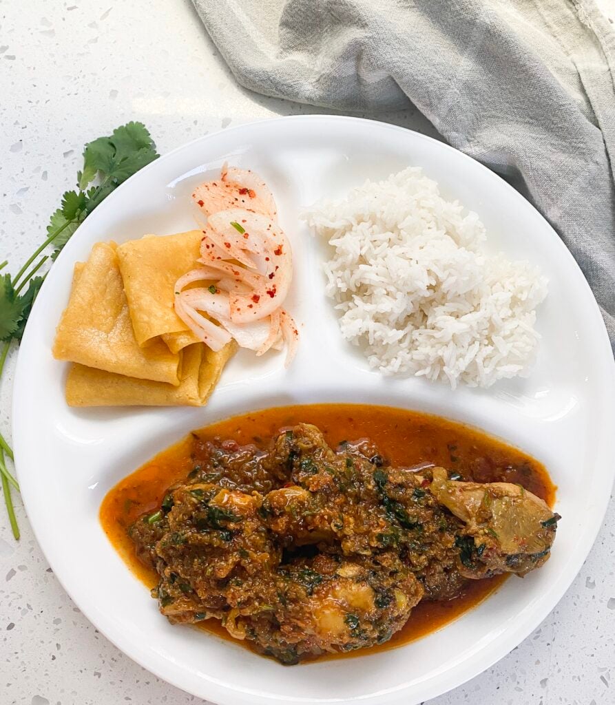 three compartment dish with desi chicken in the large, basmati rice and tortilla in small