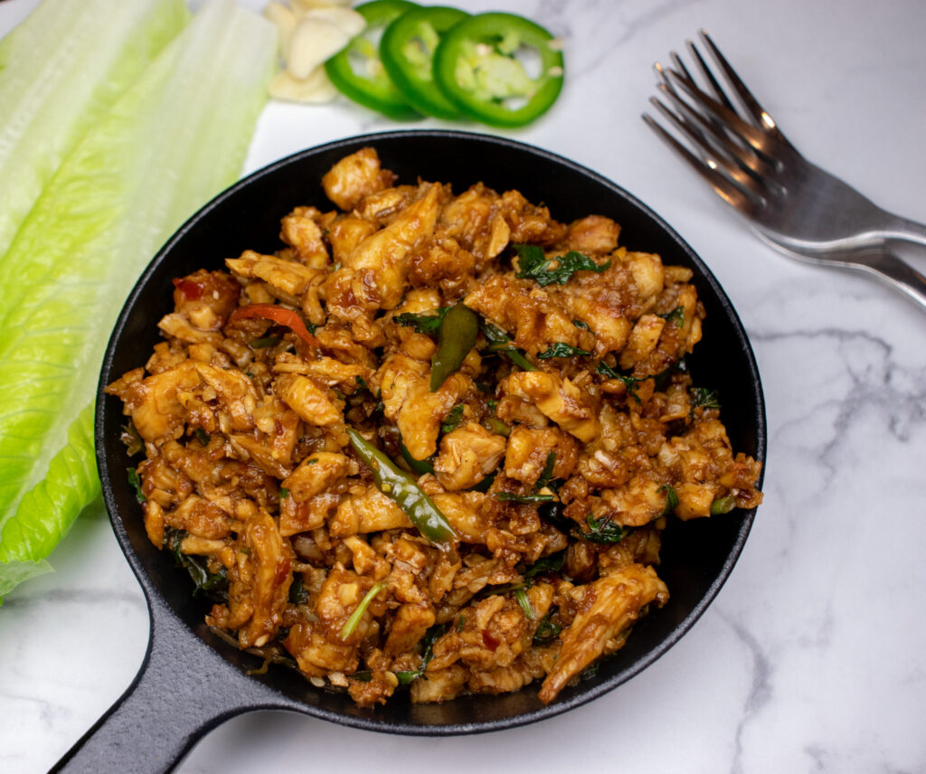 a cast iron pan with minced chicken and spices. an asian fusion recipe 