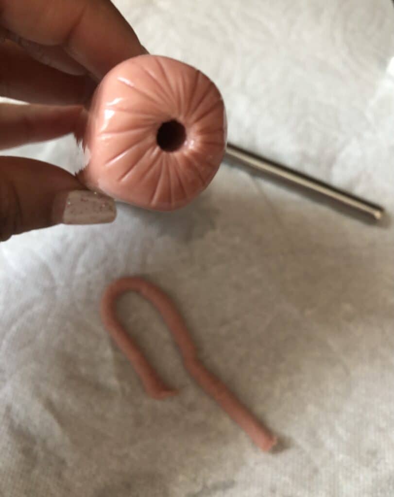 hole in a hot dog with a metal straw