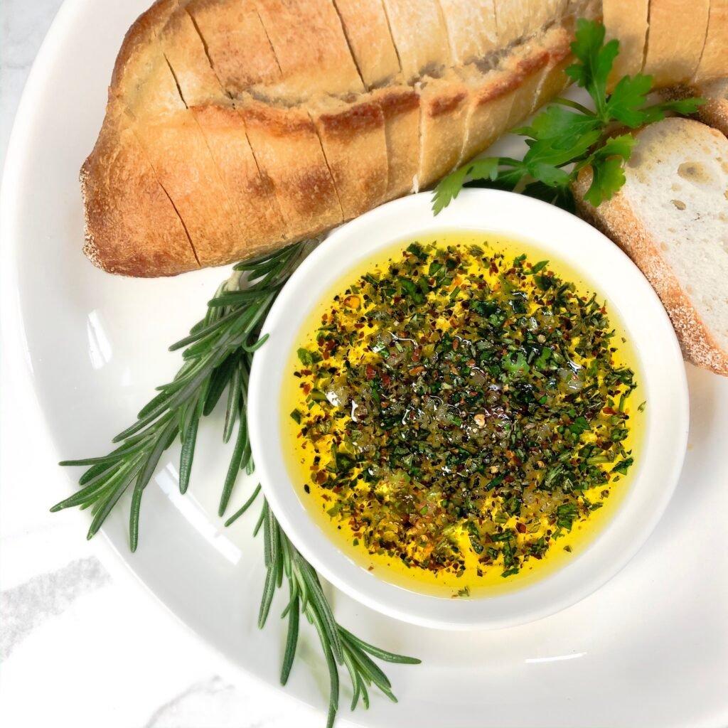 fresh herbs, bread, and a small plate with oil and herbs for dipping