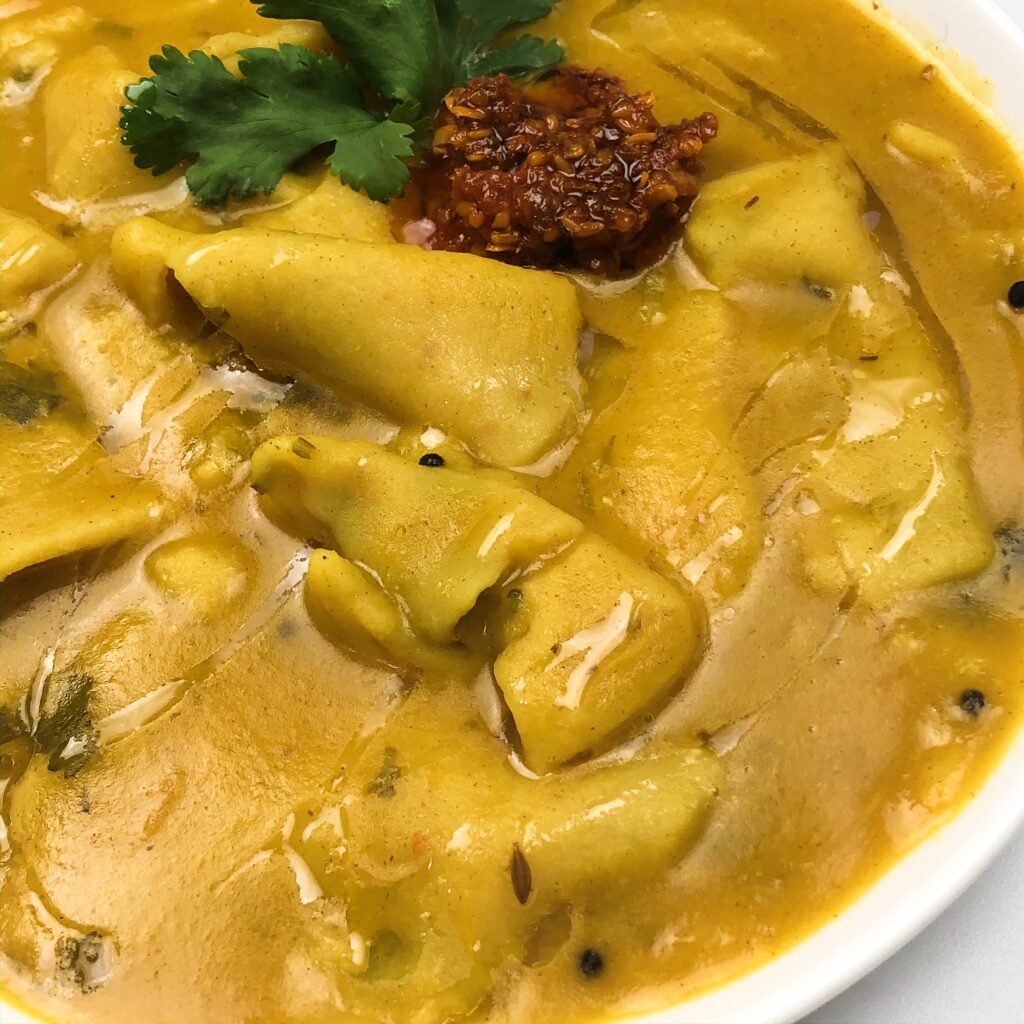 dal soup with mustard seeds and wheat dumplings. Maroon achaar and cilantro leaf.