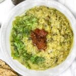 kichdi in a bowl with achaar and cilantro