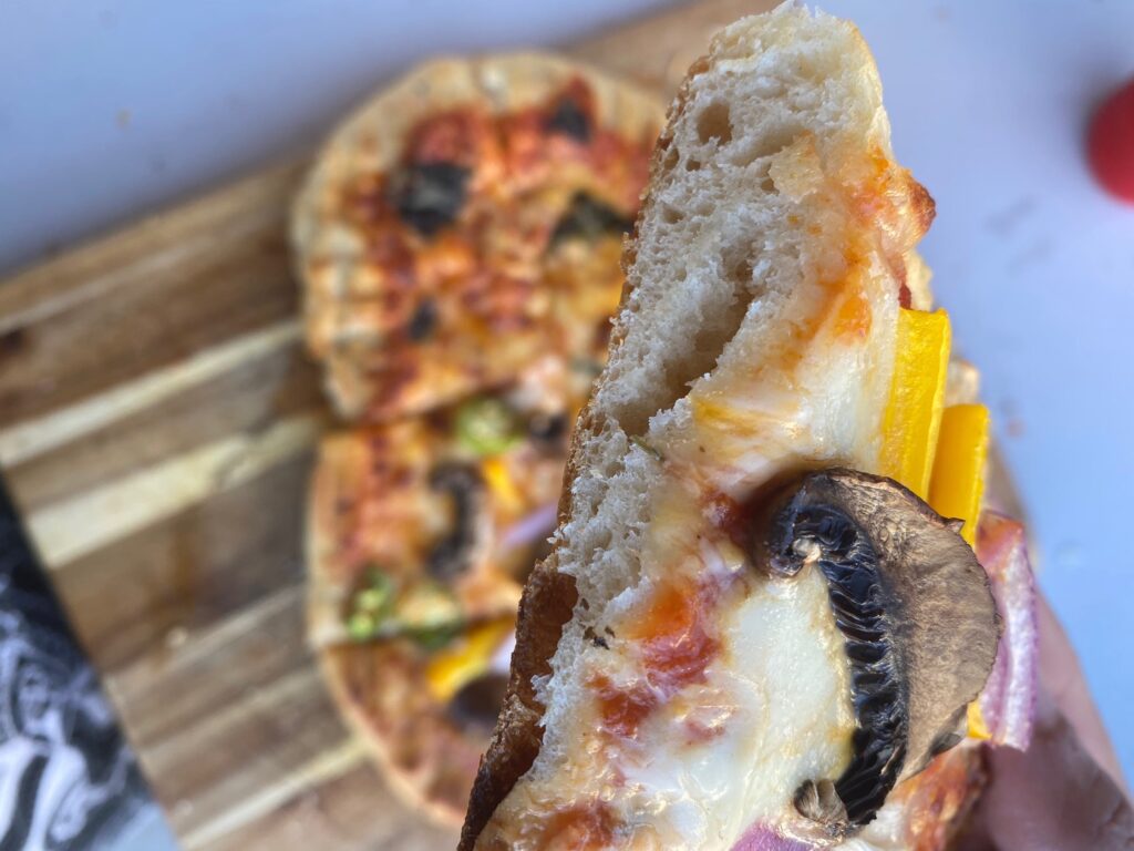 A pizza crust that has been grilled and showing all the perfect air bubbles in the middle of the crust.