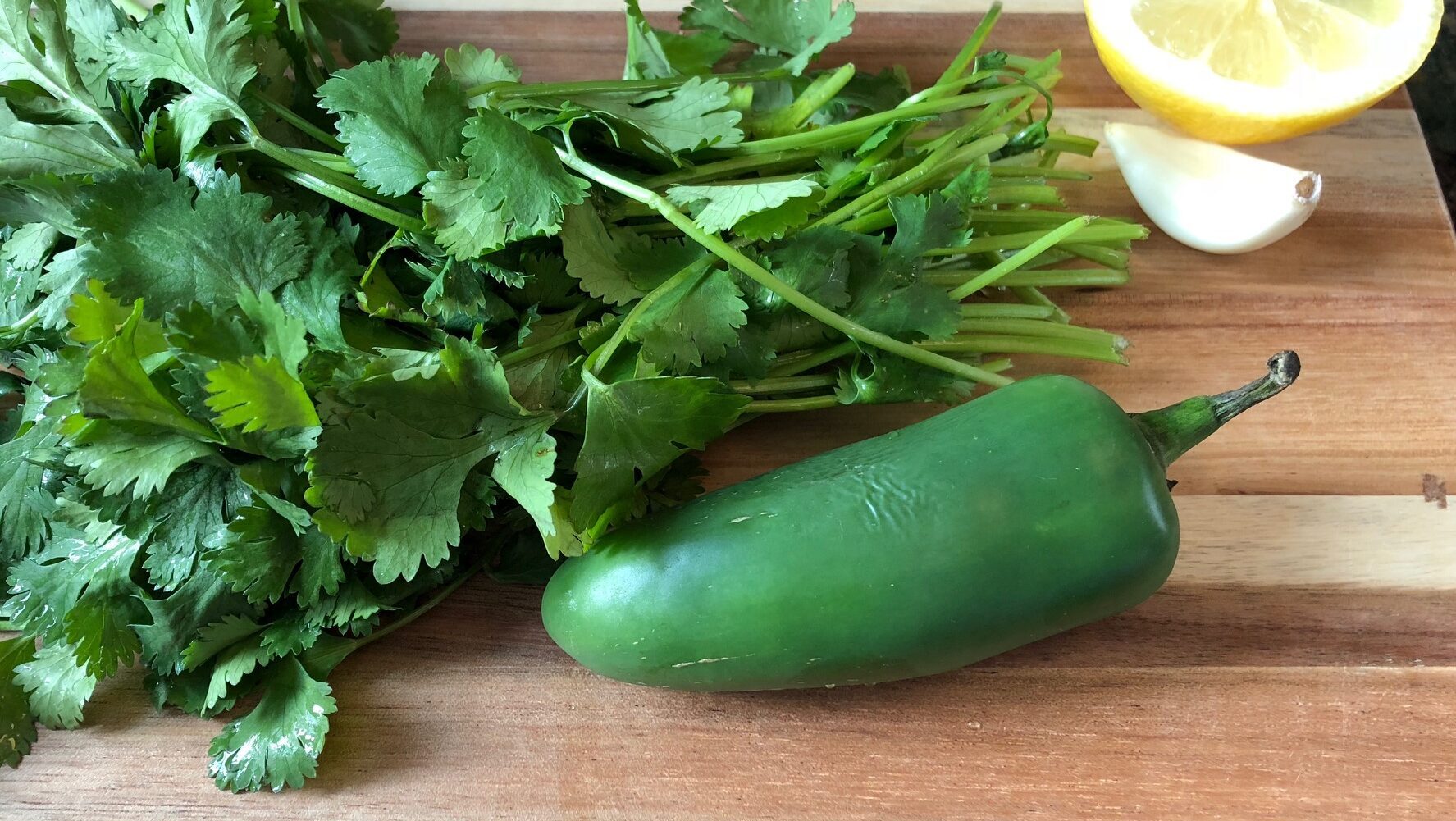 cilantro and jalapeno on a cutting board