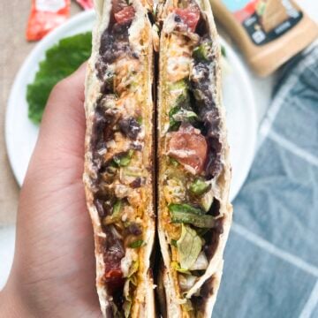 inside of a crunchwrap supreme being held in one hand.