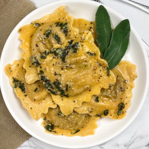 a bowl full of ravioli with sage butter on top