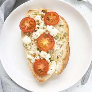 toasted french bread with oil feta cheese and cherry tomatoes parsley topped